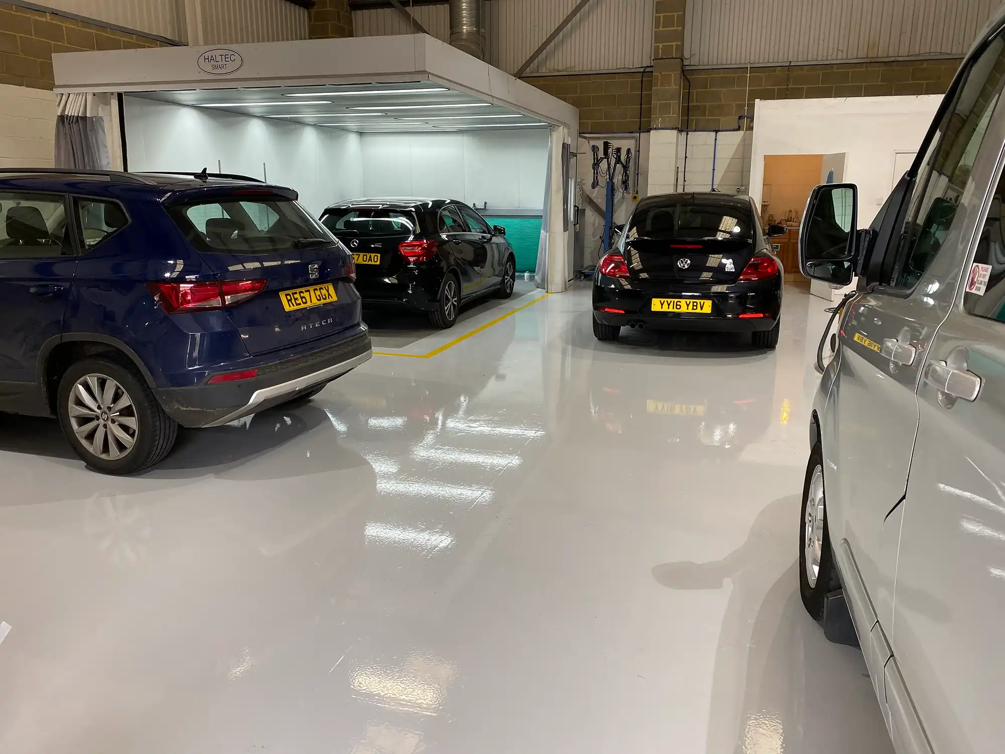A garage with several cars parked in it.