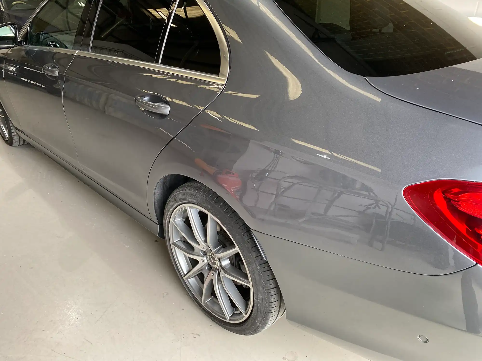 A silver car is parked in a garage.